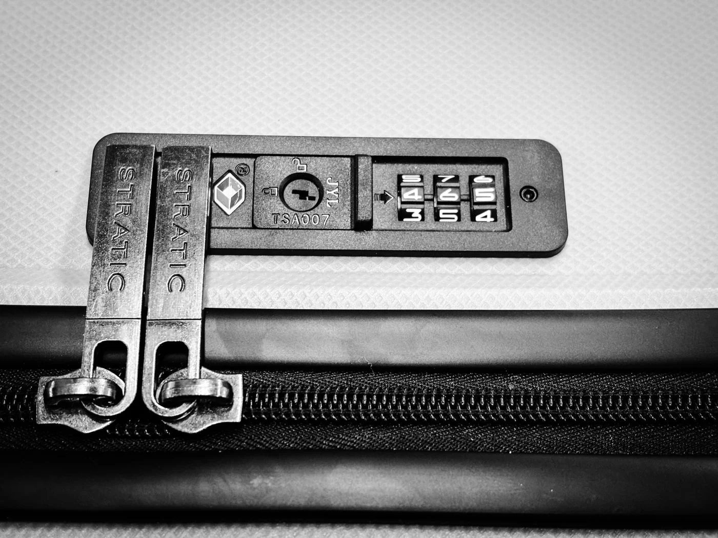Close-up of a suitcase zipper and its integrated locking mechanism.