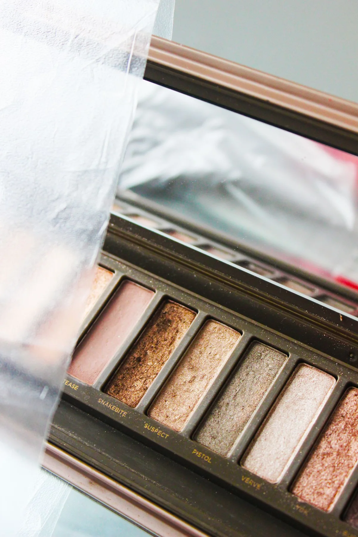 An open makeup palette with pans and an integrated mirror.