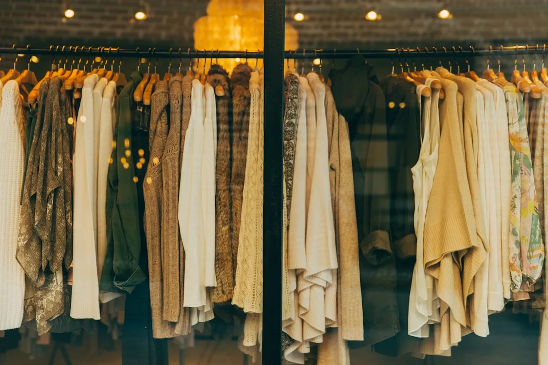 A selection of garments displayed in a warmly lit clothing shop